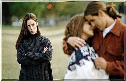 Woman staring at young couple holding each other