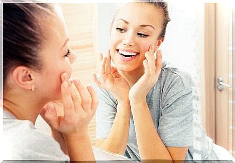 Woman smiles to herself in the mirror.