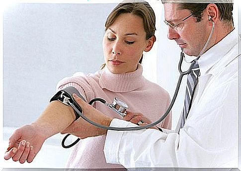 Woman having her blood pressure taken by the doctor