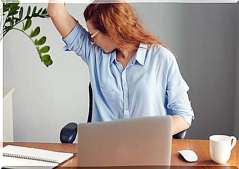 Woman smelling herself under arm