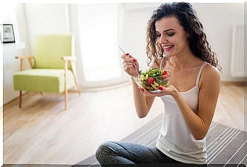 Woman eating salad in the living room