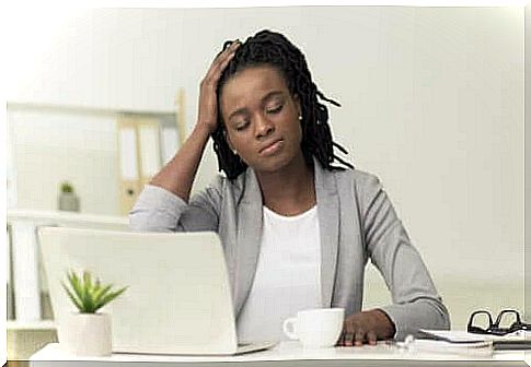 Woman at desk having headache