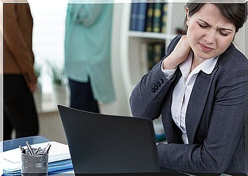 Woman at desk has a sore neck