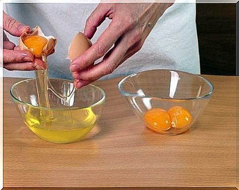 Person sorting egg whites from the plums