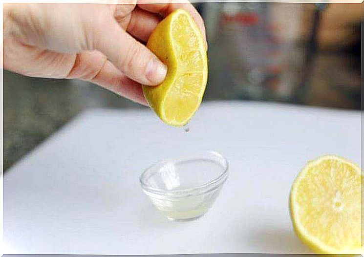 Hand squeezing lemon juice into a bowl