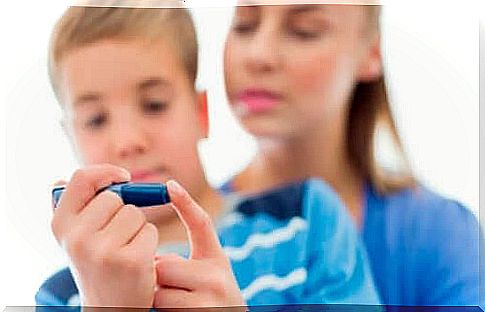 Boy checks blood sugar and is an example of children with type 1 diabetes