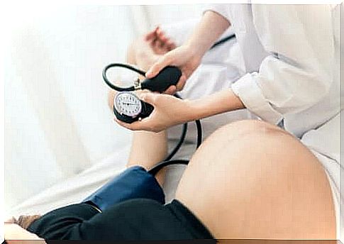 Doctor checks pregnant woman's blood pressure