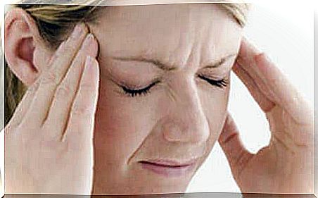 Woman with headache takes care of head