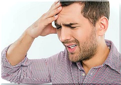 Man with headache takes care of head