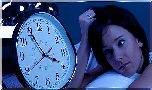 Woman lying staring at a clock