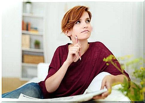 Woman sitting with newspaper and pencil