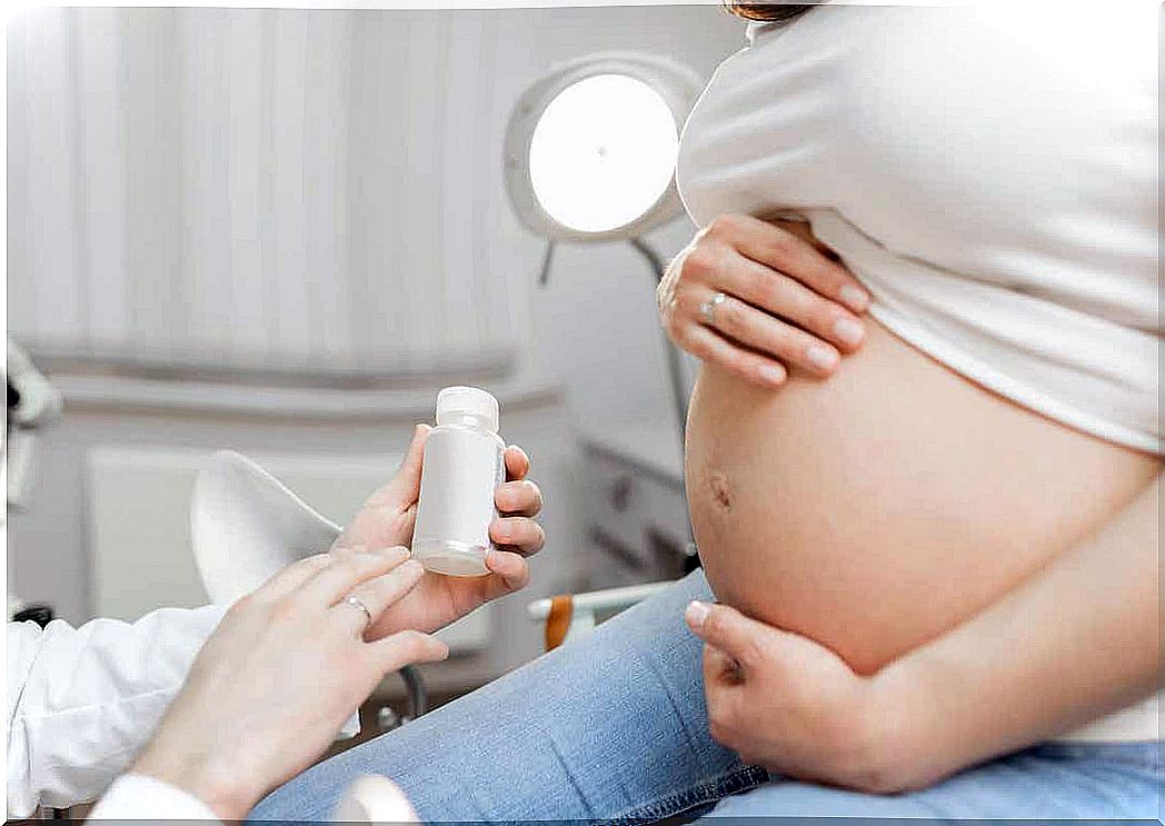 A doctor explaining something about medication to a pregnant patient